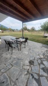 a patio with a table and benches on a stone patio at P&M APARTMENT in Ioannina