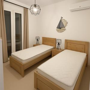 a bedroom with two beds and a sailboat on the wall at Theologos Residencies in Theologos +32 photos