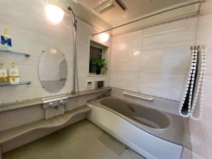 a bathroom with a tub and a mirror at Golf house - Vacation STAY 9043 in Ryūgasaki +65 photos