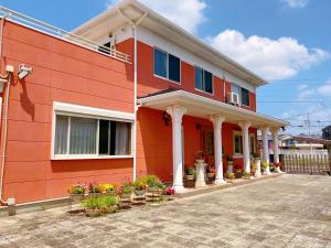 a red house with flowers on the side of it at Golf house - Vacation STAY 9043 in Ryūgasaki