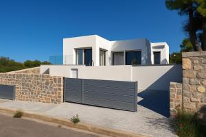 a white villa with a gate in front of it at Theologos Residencies in Theologos