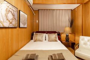 ein Schlafzimmer mit einem Bett und einem Stuhl in der Unterkunft ASAHI HOUSE 2nd floor - Vacation STAY 92767 in Naha