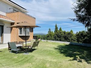 a patio with a table and chairs and an umbrella at Sumoto - House - Vacation STAY 91396 in Sumoto +17 photos