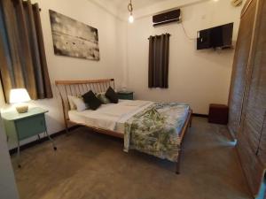 a bedroom with a bed and a television in it at The Anex in Kalawana
