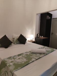 a bedroom with a bed with a green and white blanket at The Anex in Kalawana +14 photos