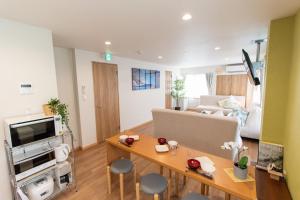 ein Wohnzimmer mit einem Tisch und einem Sofa in der Unterkunft TK Court Ojima - Vacation STAY 91237 in Tokio