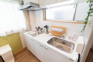 eine kleine Küche mit Spüle und Fenster in der Unterkunft TK Court Ojima - Vacation STAY 91237 in Tokio + 73 Fotos