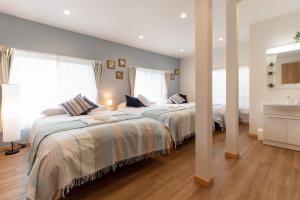 2 Betten in einem Schlafzimmer mit 2 Fenstern in der Unterkunft TK Court Ojima - Vacation STAY 91237 in Tokio