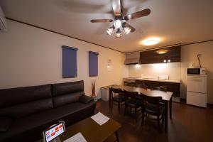 a living room with a couch and a table and a kitchen at Takanoya Hoshi - Vacation STAY 91923 in Yufuin