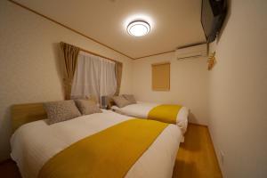 two beds in a small room with a window at Takanoya Kumo - Vacation STAY 91939 in Yufuin