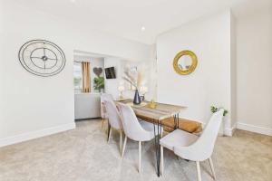 a dining room with a table and chairs and a clock at Host & Stay - Jomor House in Burnhope