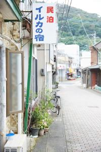a sign on the side of a building with a bike parked outside at Iruka House 1 - Vacation STAY 9266 in Iki