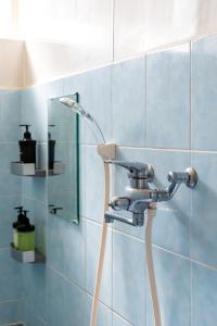 Una ducha en un baño con una pared de azulejos azules. en ASAHI HOUSE 2nd floor - Vacation STAY 92770, en Naha