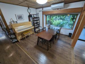 a dining room with a table and a piano at guest house Ki-zu - Vacation STAY 96116v in Nishio