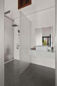 a white bathroom with a shower and a sink at Sila Ananda 6BR Pool Villa Đảo Xanh Đà Nẵng in Da Nang +43 photos