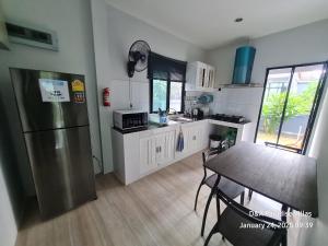 a kitchen with a stainless steel refrigerator and a table at D&A Paradise Villas in Koh Samui