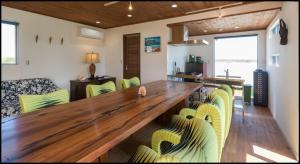 a dining room with a large wooden table and yellow chairs at Beach Front House Suzuka - Vacation STAY 9364 in Suzuka