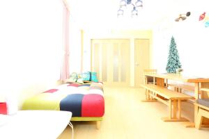 a room with a bed and a table with a christmas tree at Sun River Annex Inaho - Vacation STAY 95961 in Kita-hamachō