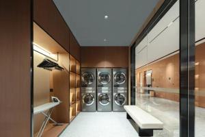 Atour Hotel Hohhot Hailiang Plaza Zhongshan Road Subway Station في هوهوت: غرفة غسيل مع اربع غساله ونشافه