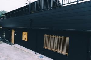a black building with a gate on the side of it at Setouchi Hitotsuru HITOTSURU - Vacation STAY 13561v in Onomichi +2 photos