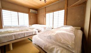 a room with three beds in a room with windows at Yuzawa Kodate - Vacation STAY 9495 in Yuzawa