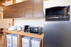 a kitchen with a counter with a microwave and a refrigerator at Me-fi-You Ishigaki Island - Vacation STAY 95379 in Ishigaki Island