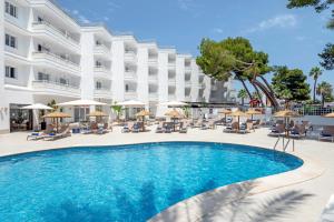 a pool in front of a hotel with chairs and umbrellas at HSM Lago Park in Playa de Muro