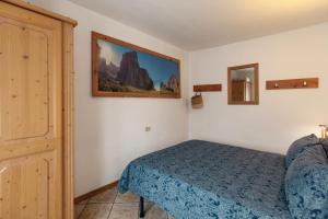 a bedroom with a bed and a mirror at Dolomitihouse CASTAGNER in Fiera di Primiero