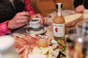 a person sitting at a table with a bottle of wine at Dolomitihouse CASTAGNER in Fiera di Primiero