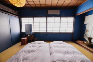 a bedroom with a large bed in a blue room at Chikugo Yoshii Guest House IKUHA - Vacation STAY 00074v in Ukiha