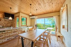 a dining room with a wooden table and chairs at Oceanic House TAMATEBAKO - Vacation STAY 98444 in Ito