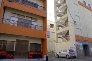 a car parked in front of a building with a parking sign at Guest House Orange no Kaze - Vacation STAY 01298v in Imabari
