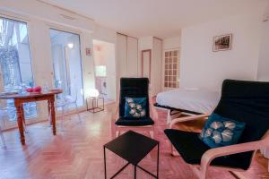 Un dormitorio con una cama y una mesa y sillas. en Le Saint-Sulpice - Résidence calme, terrasse, en Issy-les-Moulineaux