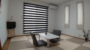 a room with a table and two chairs and a window at Guest House Mulberry - Vacation STAY 9580 in Kirishima