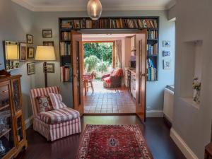 a hallway with a living room with bookshelves at Pass the Keys Charming 3-Bed Bungalow with Character Garden in London