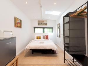 a bedroom with a bed and a flat screen tv at Pass the Keys Charming 3-Bed Bungalow with Character Garden in London