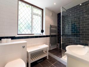 a bathroom with a toilet and a sink and a window at Pass the Keys Charming 3-Bed Bungalow with Character Garden in London +27 photos