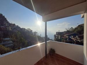 un balcón de una casa con vistas a la ciudad en Sat Chit Ananda bhavan, en Darjeeling
