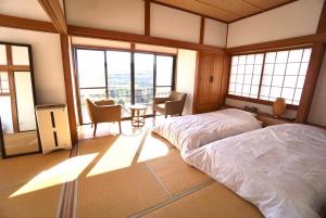 a bedroom with a bed in a room with windows at and SEA Kamogawa - Vacation STAY 07561v in Kamogawa