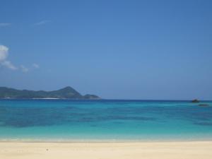 a beach with blue water and a mountain in the background at Amami Lucky House - Vacation STAY 07619v in Amami +5 photos