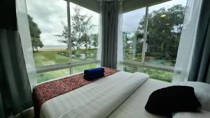 a bedroom with a bed and a large window at Papar Beachfront View in Papar