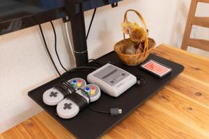 a table topped with a table with consoles and a basket at Fuchsia - Vacation STAY 20104v in Nagoya +25 photos