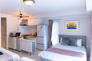 a bedroom with two beds and a kitchen with a refrigerator at Fuchsia - Vacation STAY 78249v in Nagoya