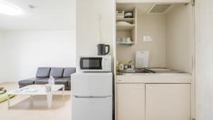 eine kleine Küche mit Kühlschrank und Mikrowelle in der Unterkunft Marvelous Higashioi - Vacation STAY 53210v in Tokio