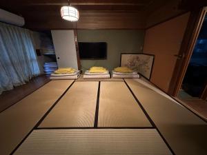 Zimmer mit 3 Betten in einem Zimmer mit einem TV in der Unterkunft Marina and Numazu DX1F - Vacation STAY 64527v in Numazu