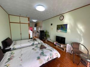 名户NAGO Sakura Resort Inn - Vacation STAY 14447v的卧室里有一张床，墙上挂着一个钟