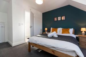 Un dormitorio con una cama grande con una pared azul. en *Discounts/Contractors/WIFI/Free Parking/Smart TV, en Gateshead 19 fotos más