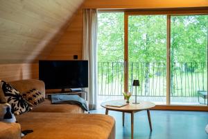 a living room with a tv and a large window at HEIMATEL - A Huesle in Oberreute