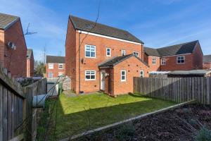 a brick house with a fence in a yard at *Discounts/Contractors/WIFI/Free Parking/Smart TV in Gateshead
