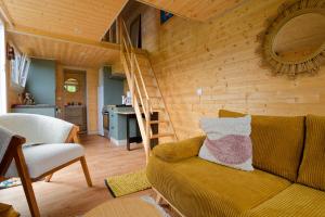een woonkamer met een bank en een houten muur bij La Tiny d'Utah Beach - Proche de la plage in Sainte-Marie-du-Mont